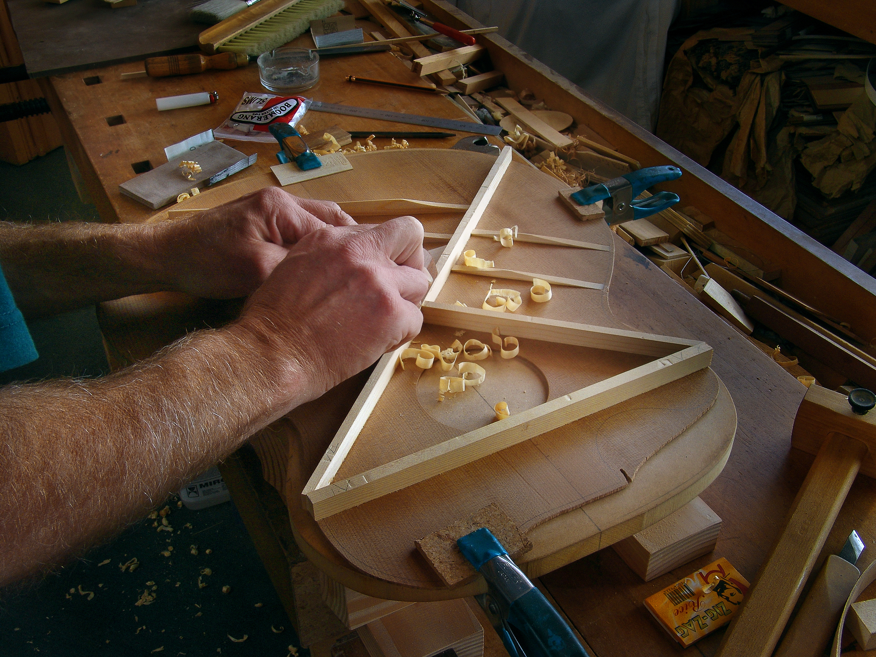 Luthier Peter Stephen shapes the bracing for the sounboard on an acoustic guitar