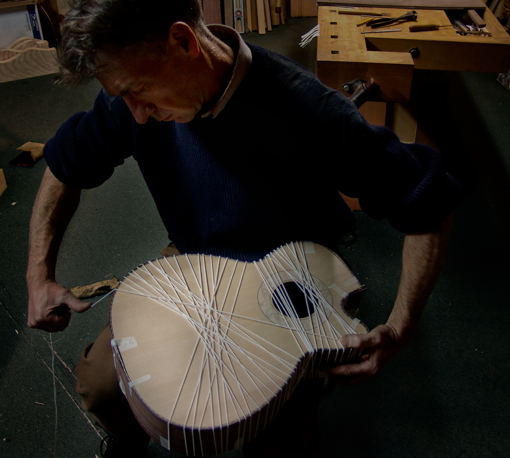 Guitar maker Peter Stephen string binds a guitar in the process of glueing the back, sides and soundboard together