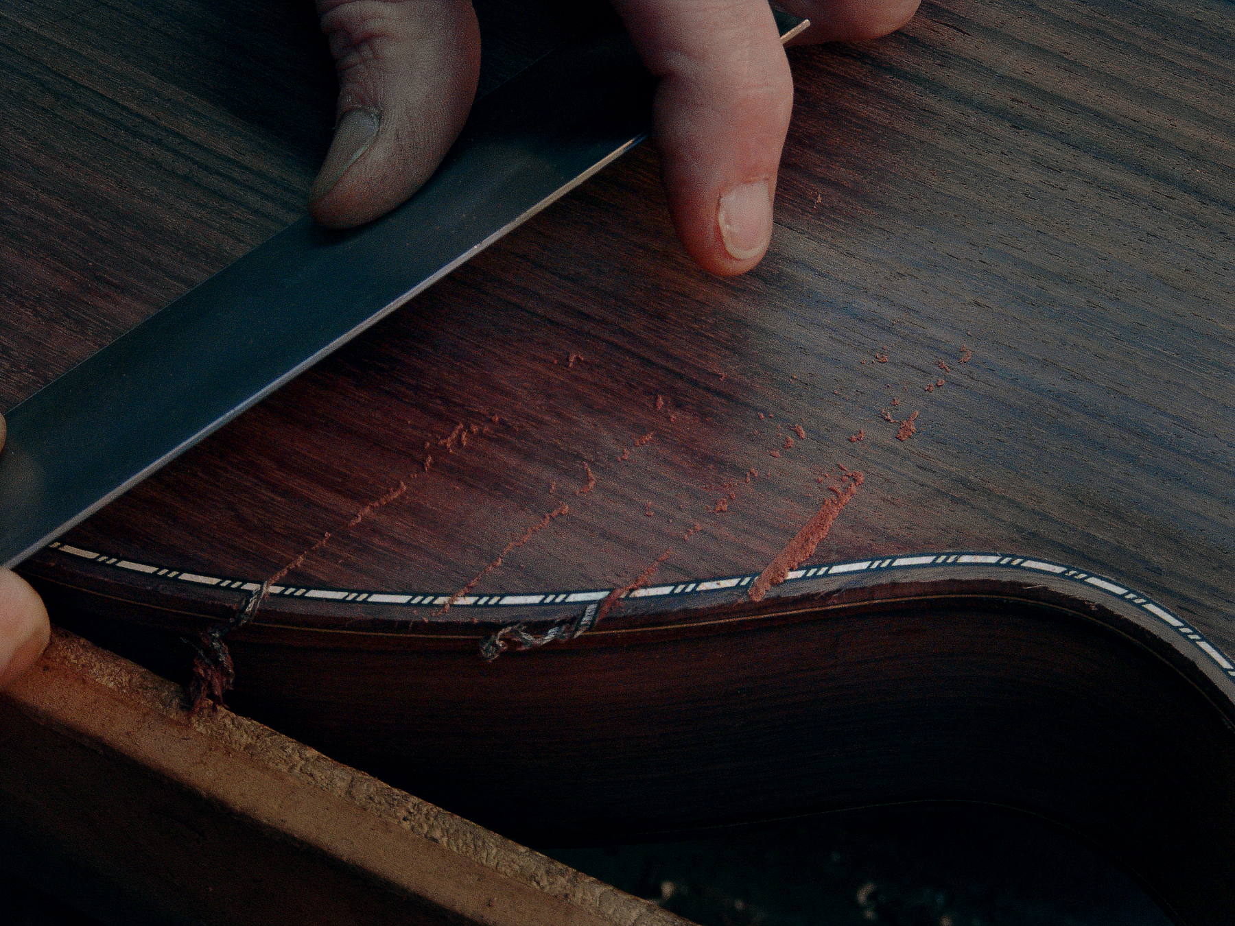 Guitar Maker Peter Stephen shaves the back and purflings of an acoustic cutaway guitar